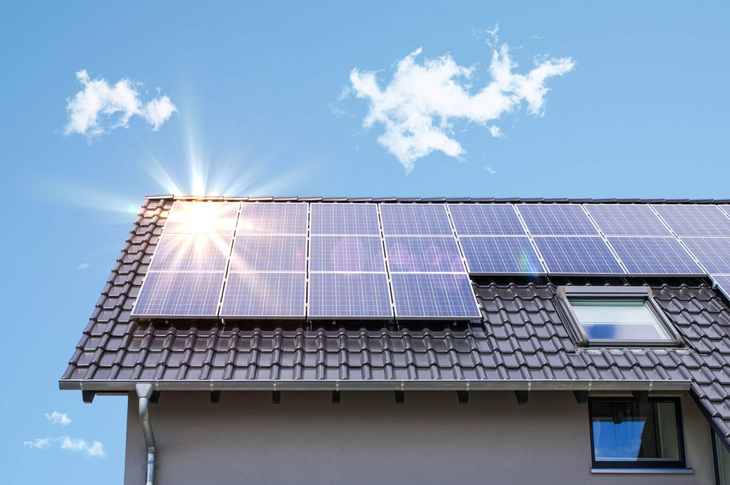 Eine Photovoltaik Anlage ist auf einem Dach angebracht, wo die Sonne drauf scheint